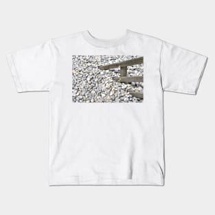 Pebbles covering a fence at  Sheringham, UK Kids T-Shirt